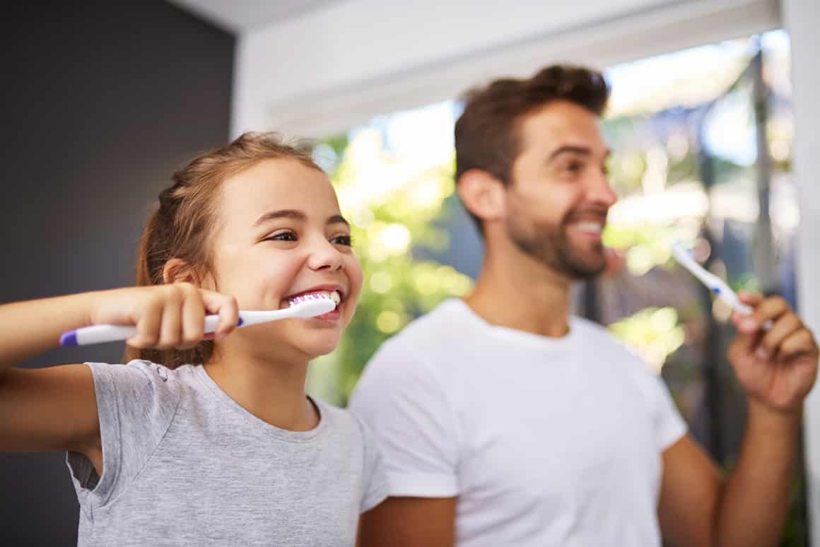 dad and daughter brushing their teeth