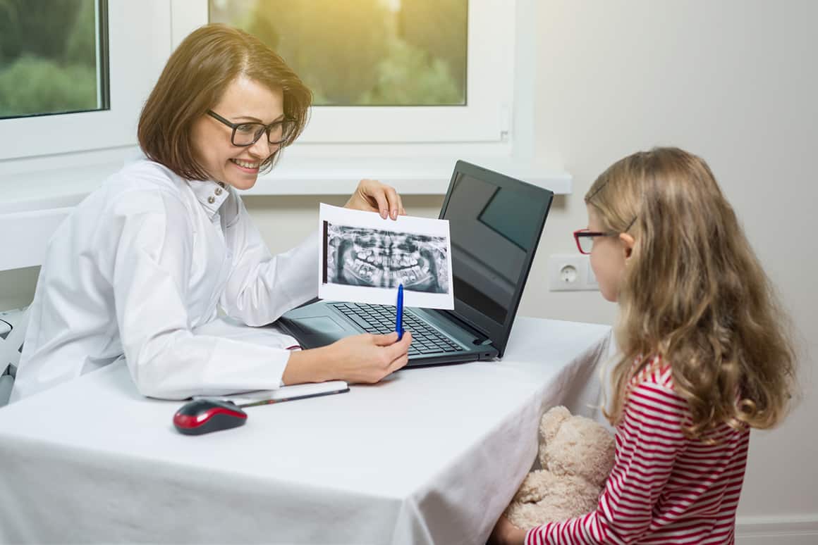 dentist showing little girl her xray at the dentist