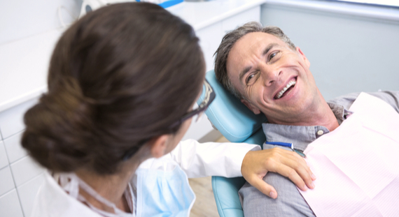 patient consulting with dentist in chair at office